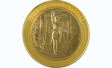 A circular boardered medal, Futers Gold Medal appears in reaised lettering on the boarder, centre depicts goddess with a lamp in a mine shaft