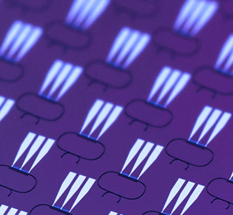 On-chip optical isolators for 780nm and 1,550nm wavelengths, fabricated in lithium niobate, purple substrate withwhite glowing lights