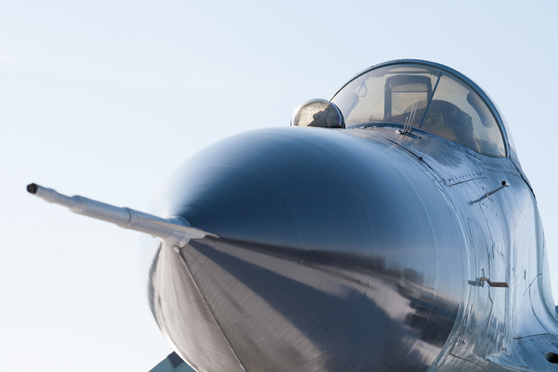 Military aircraft nose under blue sky