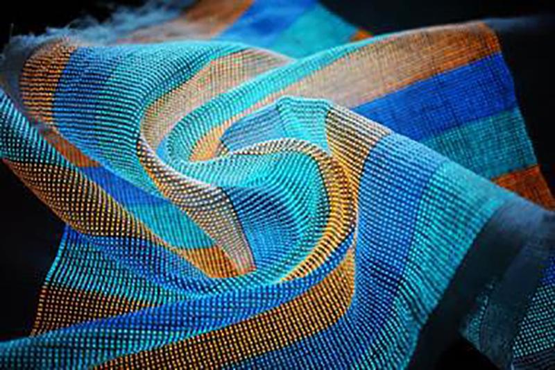 blue, green and orange textile on a bleack background