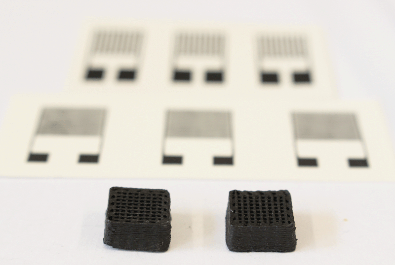 Two test cuboids 1cm wide from the 3D printer. The printed electronic sensors can be seen in the background