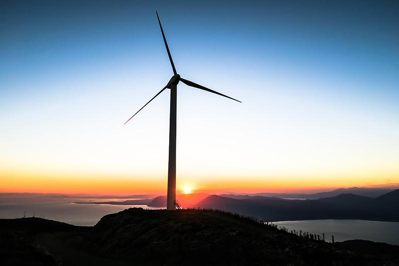 Wind turbine with sunrise on horizon