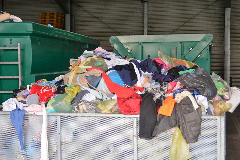 Different colours and pieces of clothing in a recycling container