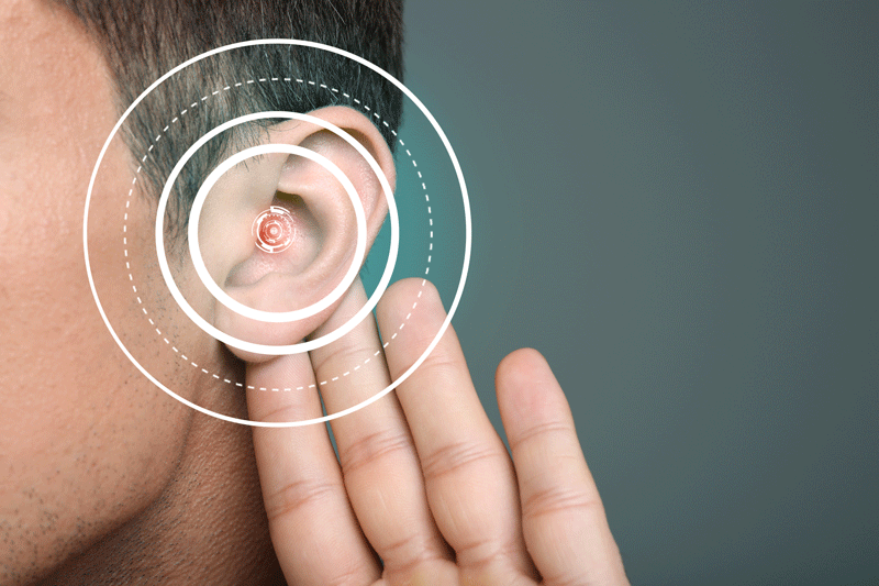 close up of an ear with a hand behind it, white circles are olerlaid on the ear to indicate sound waves