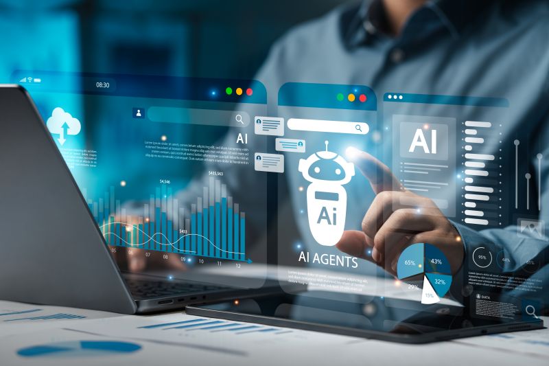 AI technology represented as images projected in the air above a computer with the interaction from a human hand.