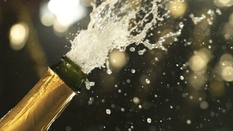 Champagne bottle with bubbles exploding from it
