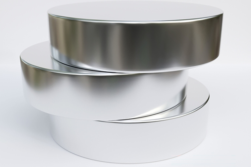 Three shiny metal short cylinders stacked vertically