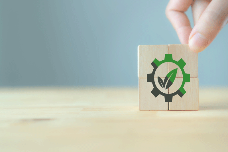 A wooden puzzle with an imprint of a leaf inside a cog being put together