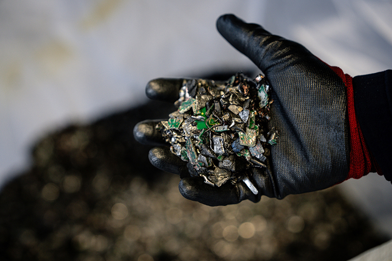 Gloved hand holding shredded battery