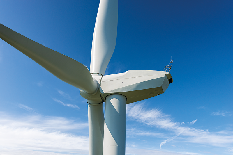 Stock image of a wind turbine against a blue sky