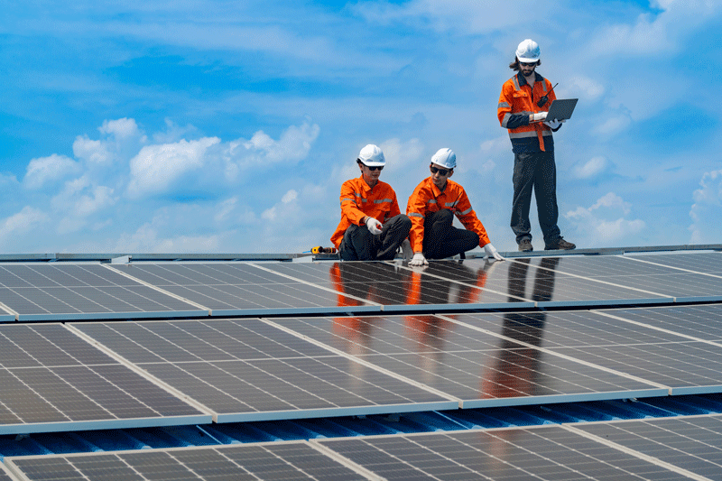 People standing on a slanted solar panel