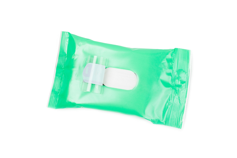 Open green packaging of white wet wipes isolated on white background. 