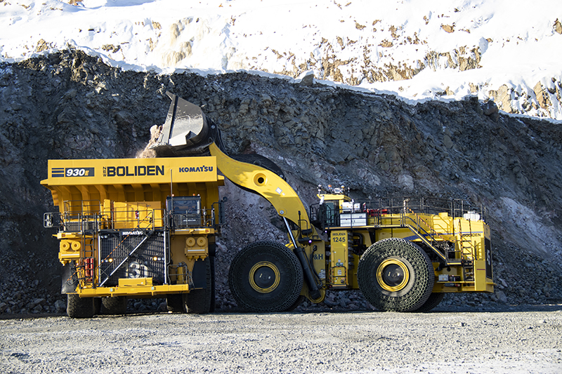 digger loads extracted ore into a lorry