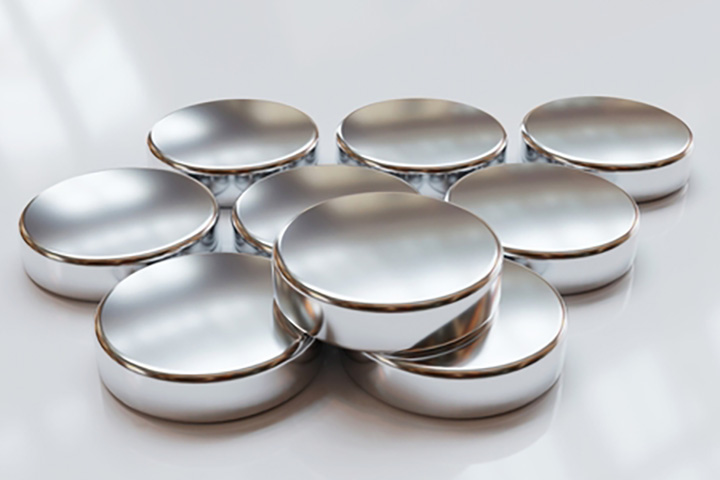 Shiny, silver-coloured metal discs or pucks, which look like neodymium magnets