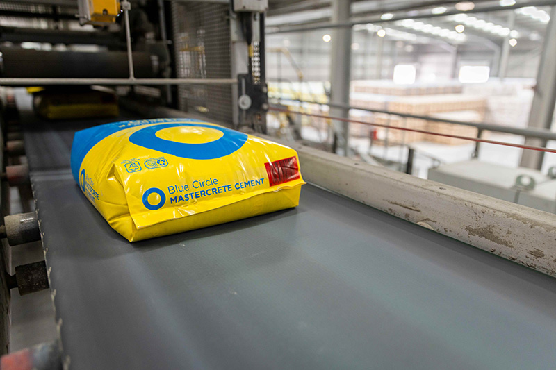 Packed cement in 80% recycled packaging on a conveyer belt