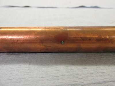 Corrosion pinhole visible on the outside of  a copper pipe