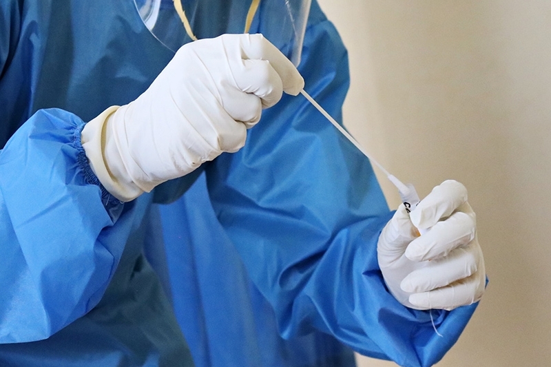 Gloved hands with swab test