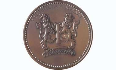 bronze circulas medal with top edge text reading Technician Medal, certre has two heraldic lions
