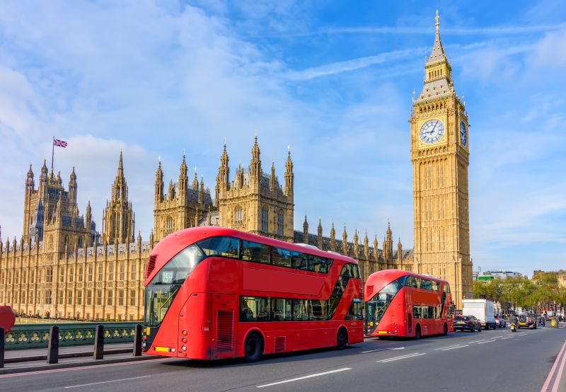R&D funding confirmed in the spending review. Houses of Parliament with Big Ben and double-decker buses on Westminster bridge, London, UK pictured.