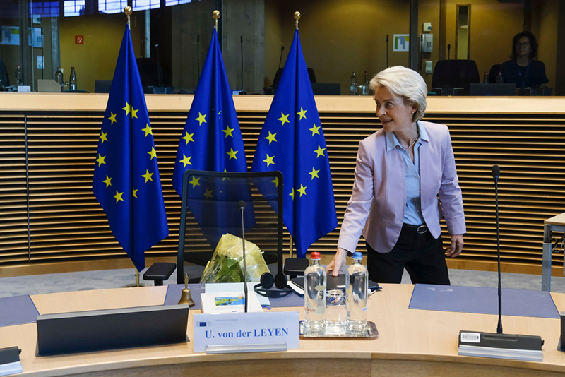 Female standing by three EU flags