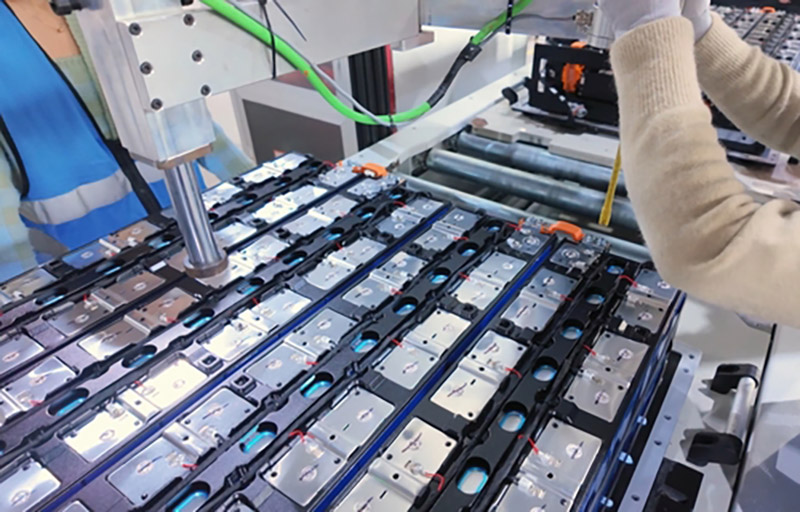 Lithium batteries on a production line with someone screwing them in place