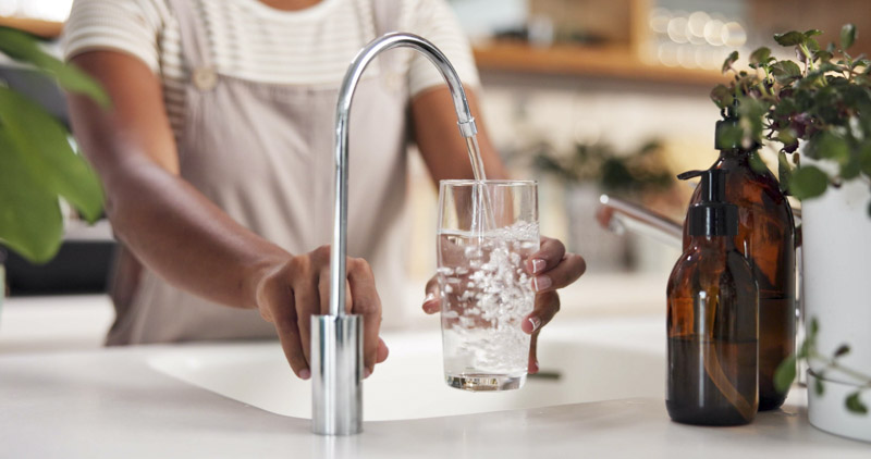 Person pouring out a glass of water