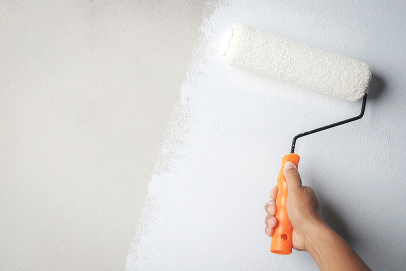 Roller Brush Painting, Worker painting on surface wall, renovating with white colour paint.