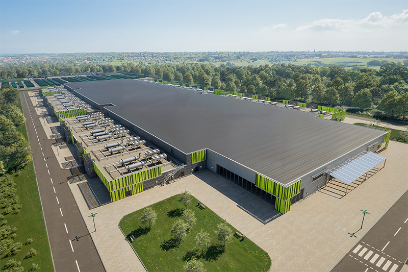 A birds-eye view of a 3D rendering a large warehouse structure with a lot of industrial pipework along both sides surrounded by a forest