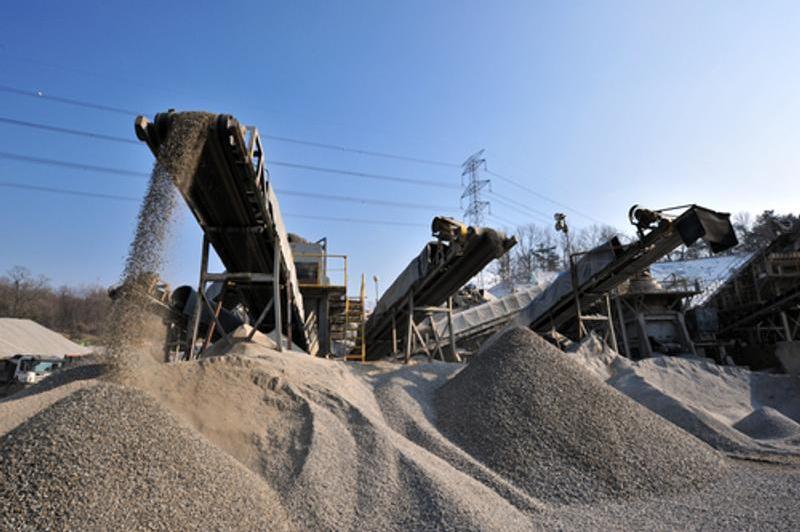 Industrial conveyor belts going up into the air carrying and dropping sand and stones in different piles of different sizes