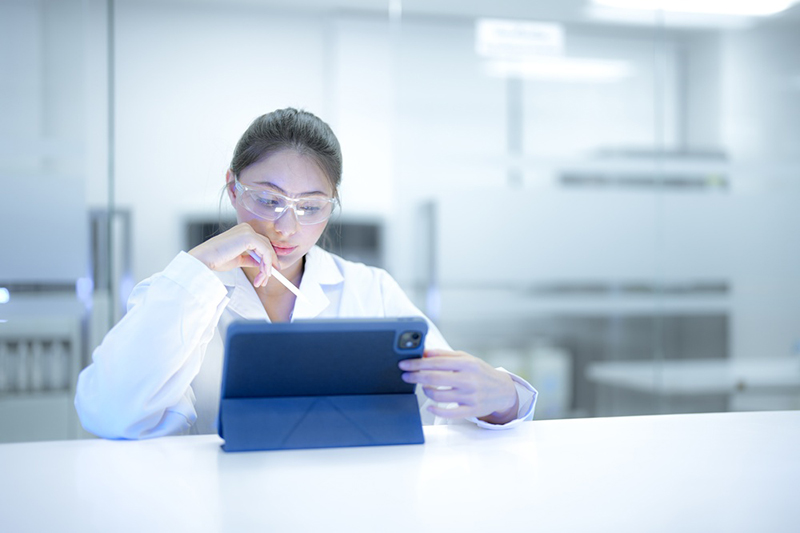 female scientist using a digital tablet to analyse research data in a modern sterile laboratory. 