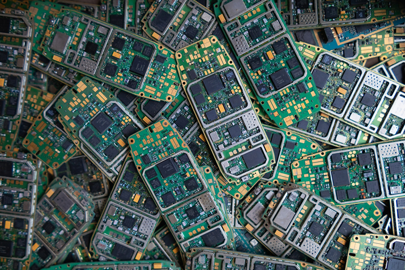A pile of phones without covers showing the circuit boards underneath