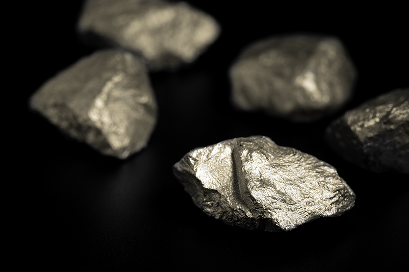 Stock image of lumps of rare-earth metals against black background
