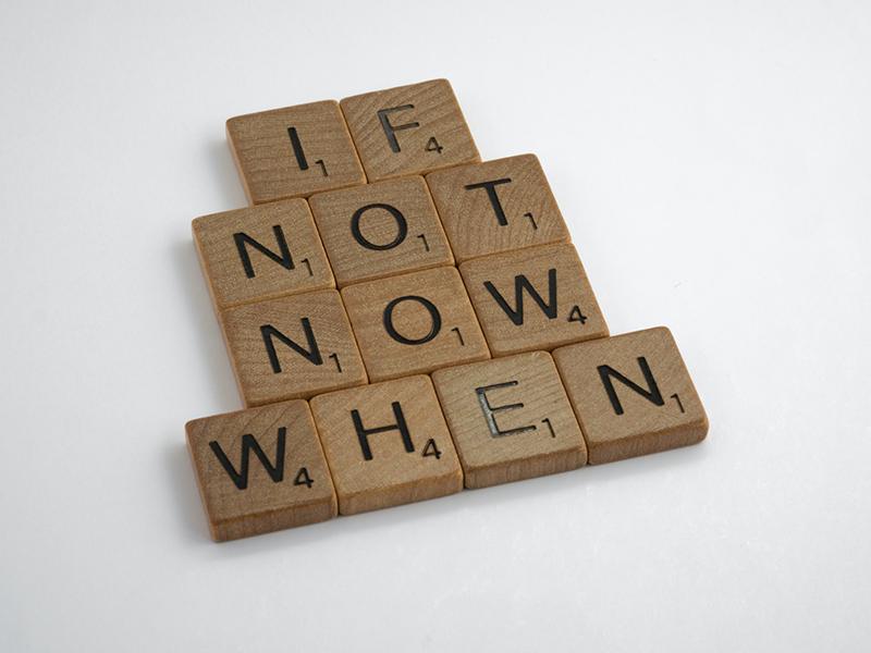 wooden scrabble tiles arragnged to read "if not now when"