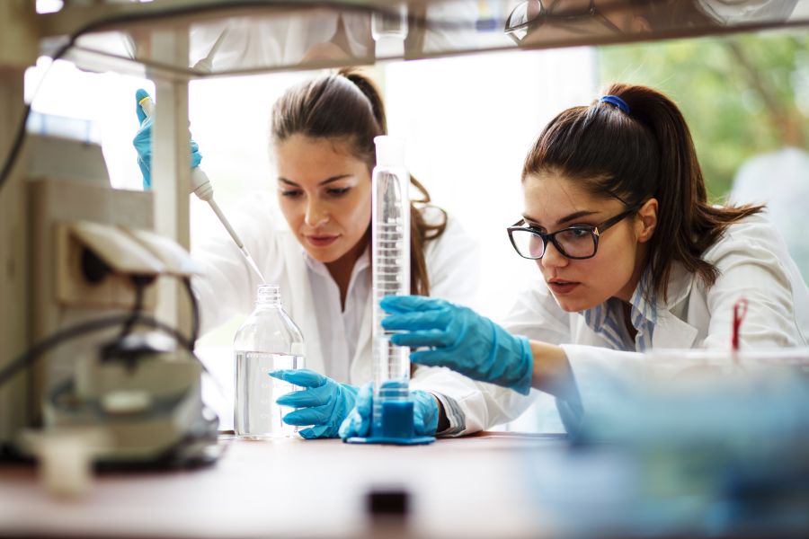 Two young female scientist doing experiments in lab pictured