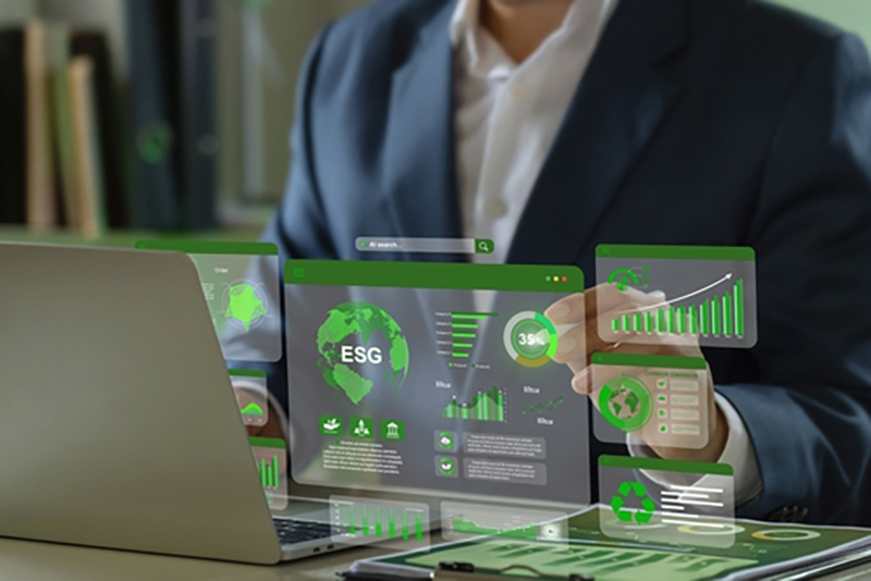 A white collar worker at a laptop with conceptual graphics of software for environmental use, such as the letters ESG