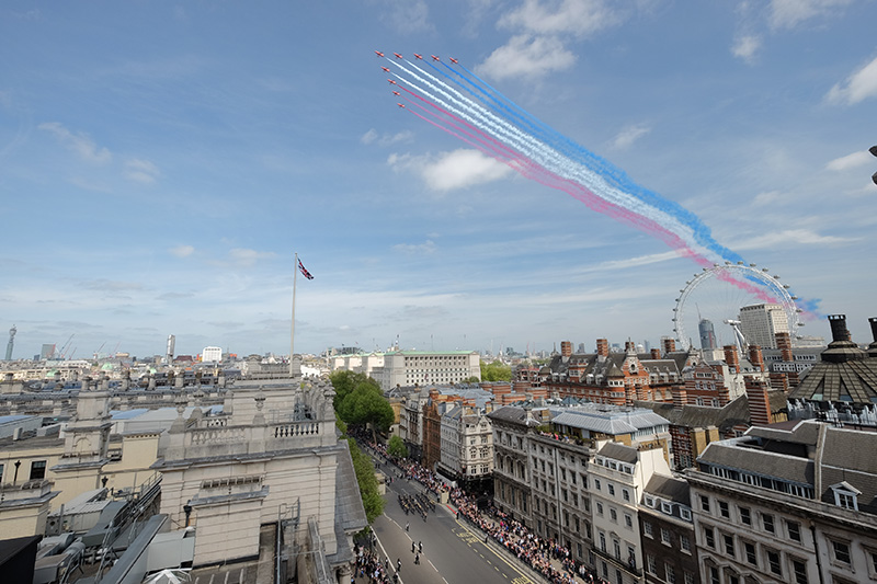 Red, white and blue vapour trails from formation flying aircraft over London