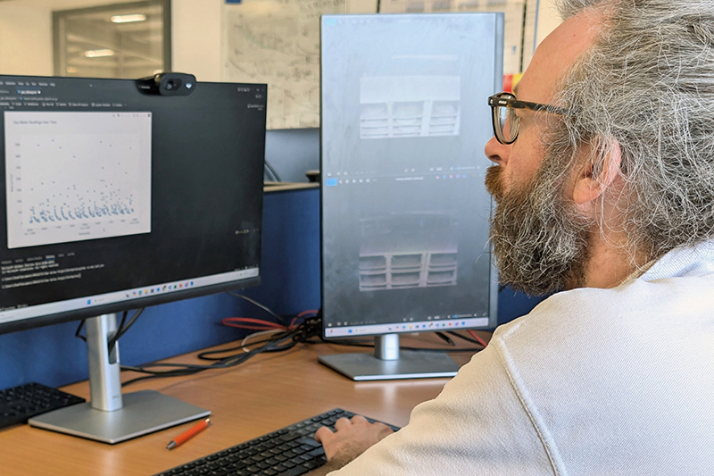 A data scientist working with a two-monitor set-up for a ceramics project
