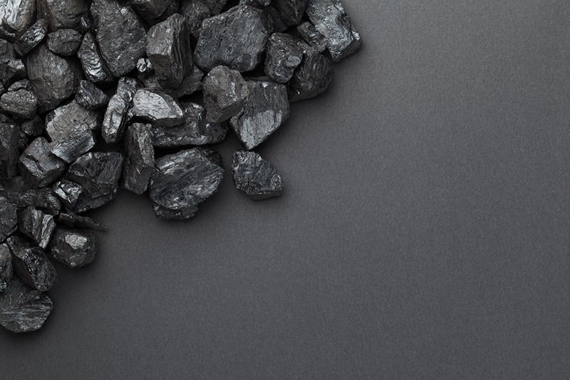 Black coal pile over dark background