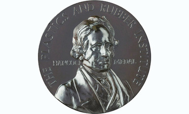 silver coloured medal raised lettering at edge reads The Plastics and Rubber Institute, centred image depicts Hancock flanked by his name