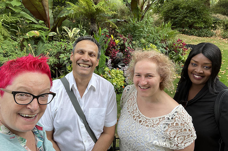 Group shot of four people in a garden in summertime