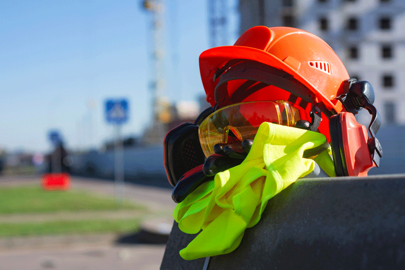 A helmet on top of some clothes left on a construction site