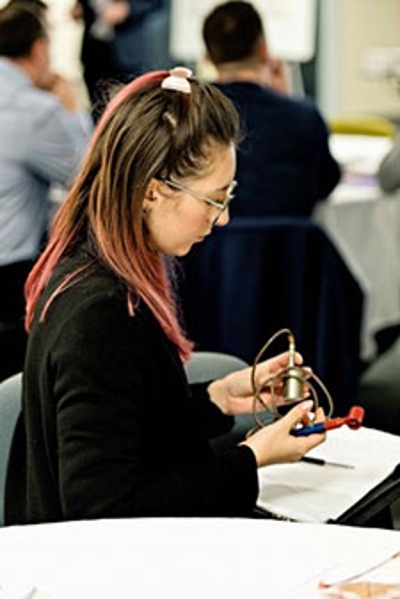 Seated female examining a piece of equipment