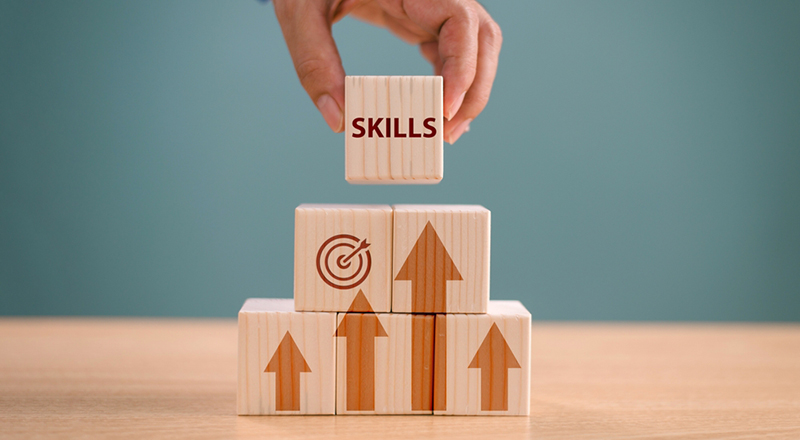 Hand holding wood cube on digital skill icon. Competency training, education concept