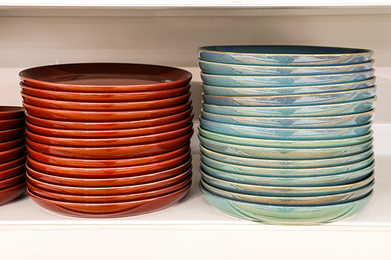 Stock image of a stack of red plates on the left and blue plates on the right