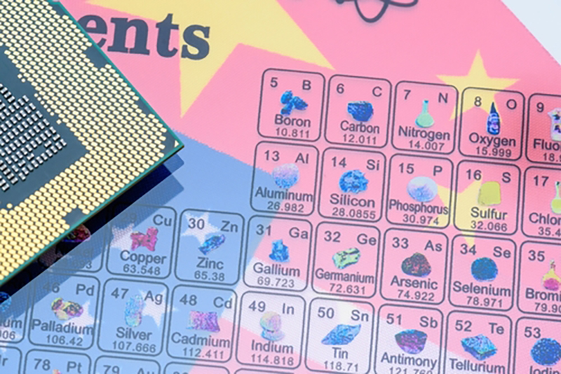 A graphic of a periodic table with icons of different elements, with vague parts of two flags in the background, and a silicon chip on top