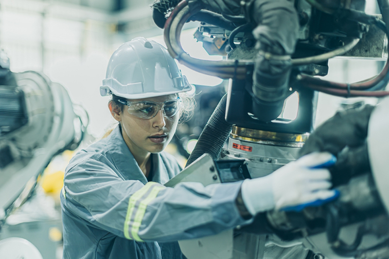 Female engineer working on machine assembly in advanced technology robotic factory