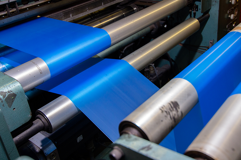 Stock image of blue-coloured films being rolled out in a manufacturing plant