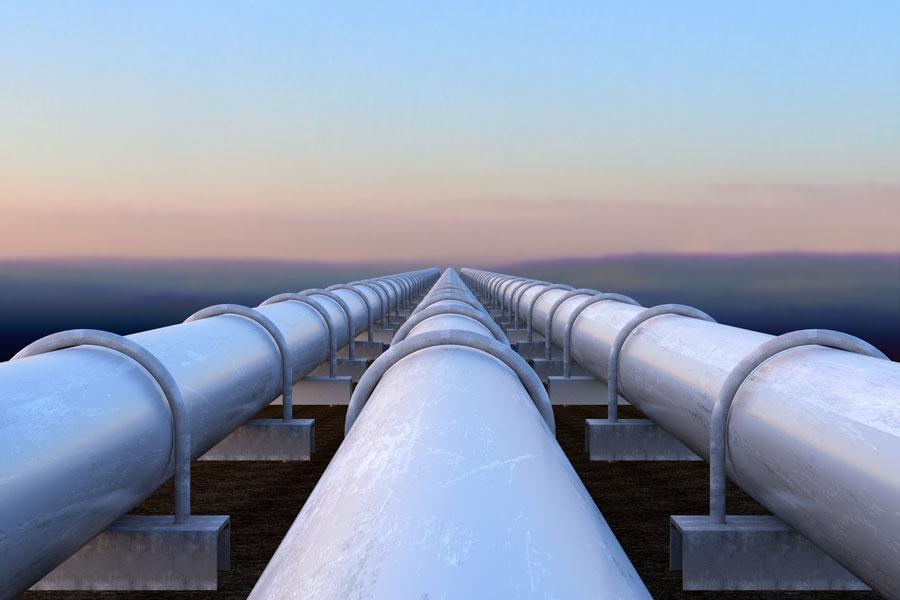 three large parallel pipes crossing a wide expanse, heading into the distance