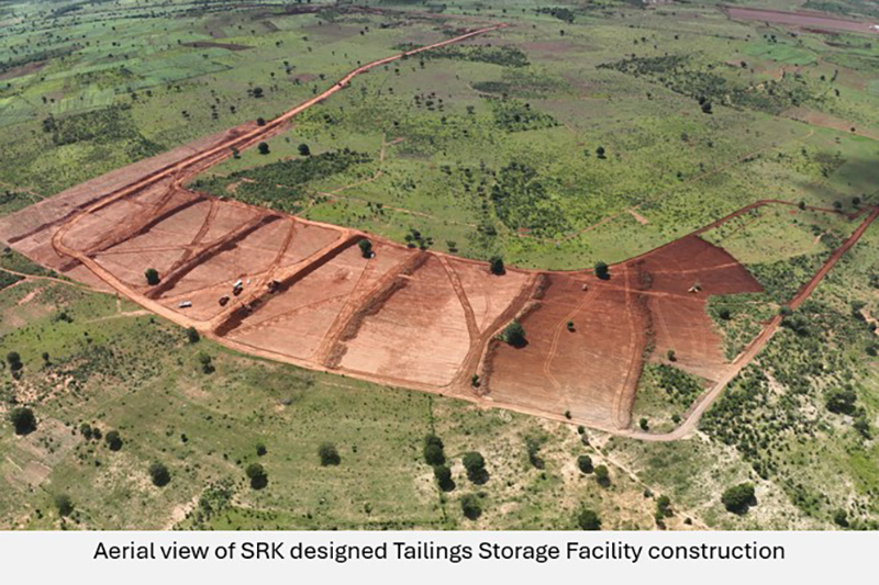 A birds eye view of a large swathe of a green, lush plain, with a large dirt C-shape carved out for the tailings area 