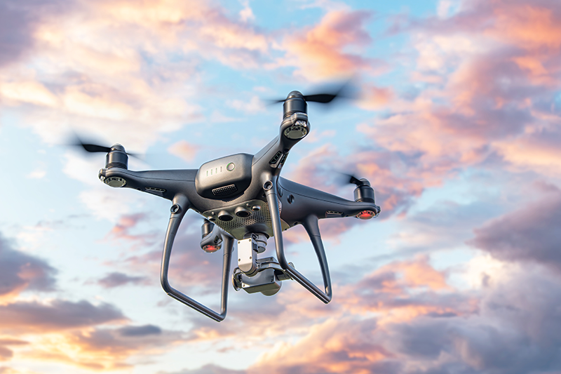 Drone flying against a sunset sky